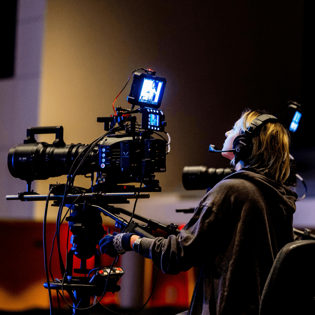 female-camera-operative-on-set-media-background-screening