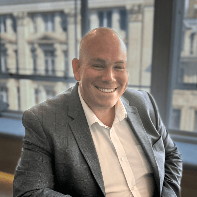 Workforce Management Experts - Julian Panter, Customer relationship Director for Matrix Workforce, in a grey suit sits by a window, with a blurred building exterior in the background.