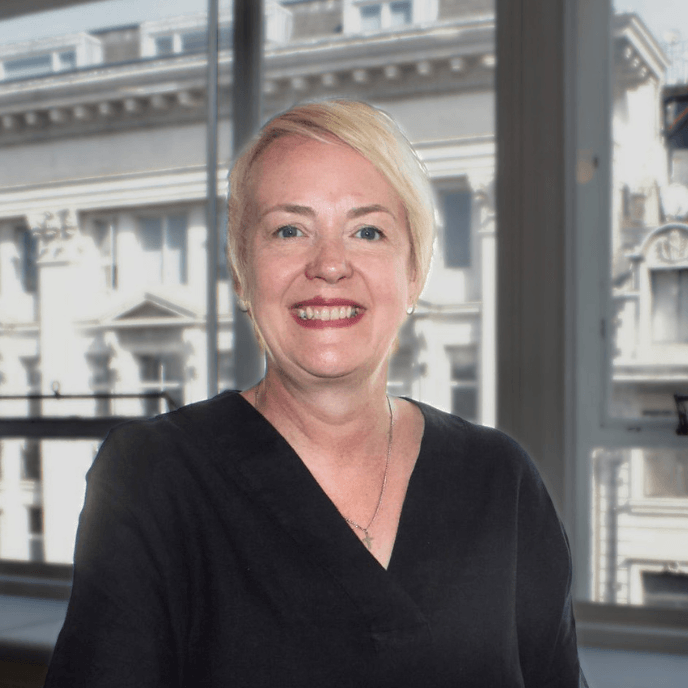 Melissa Harrison-Crowley, Customer Relationship Director for Matrix Workforce, smiling indoors with a city building visible through the window in the background.