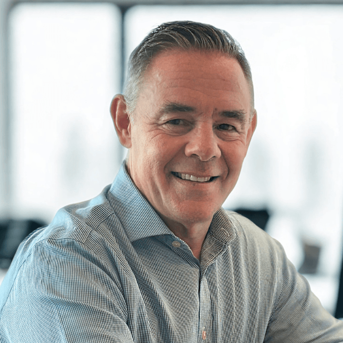 Neil Jones, Matrix CEO, in a light-coloured shirt sits in a bright room with blurred background.
