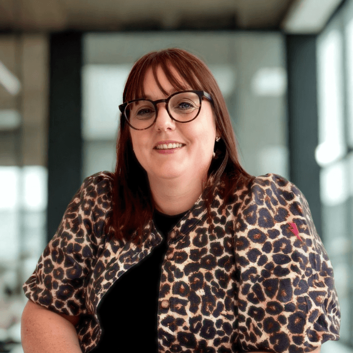 Workforce Management Experts - Rachel Keightley, Legal Counsel for Matrix, with glasses and a leopard print jacket smiles while seated indoors with soft lighting.