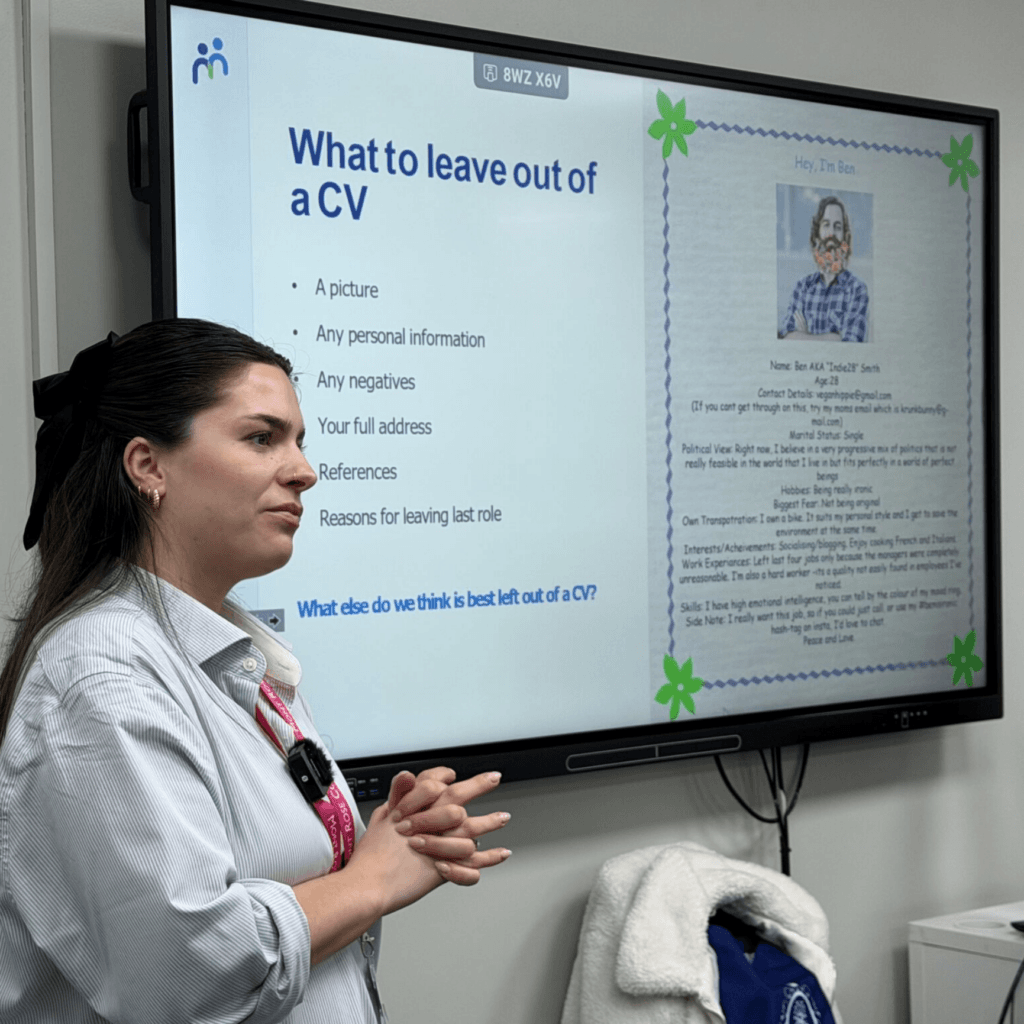 A woman presents a slide titled "What to leave out of a CV" in a classroom setting.