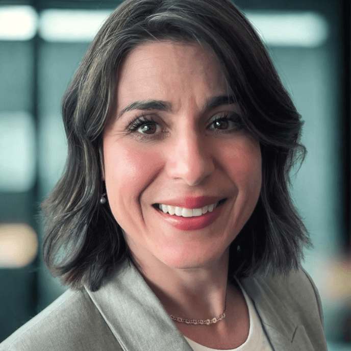 Suzi Smith, MD of Matrix Workforce and Milestone smiling in a grey blazer with short dark hair, standing indoors.