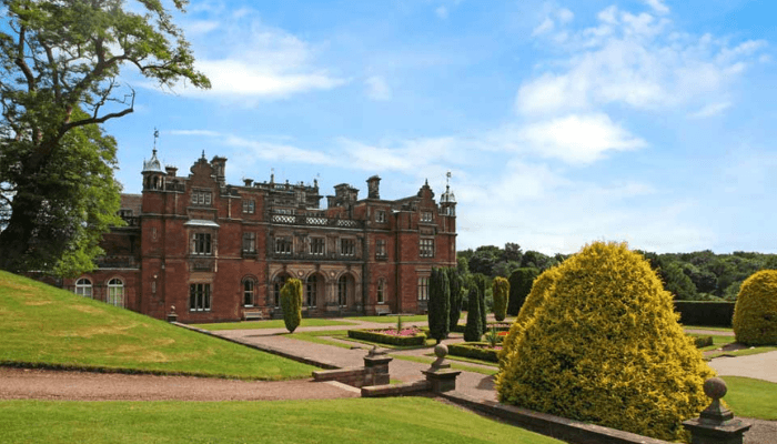 Historic red-brick Keele Hall building set among landscaped gardens at Keele University, a public sector procurement partner working with Matrix Milestone.
